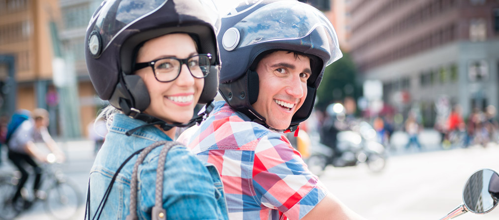 Una pareja de usuarios utilizando el servicio de Motosharing en la ciudad