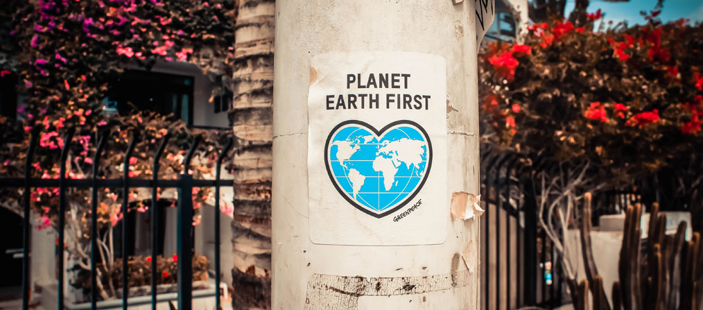 Cartel de Greenpeace con el La Tierra en forma de corazón y el lema "Planet Earth First"